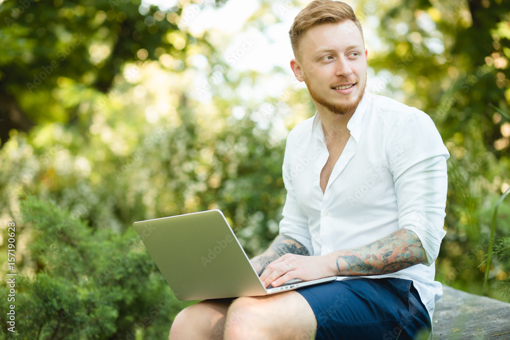 Man freelancer working with laptop in a nature