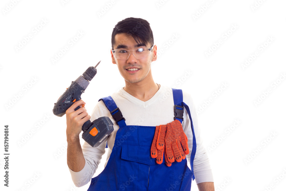 Man in overall with gloves and glasses holding electric screwdriver Man in overall with gloves and glasses holding electric screwdriver