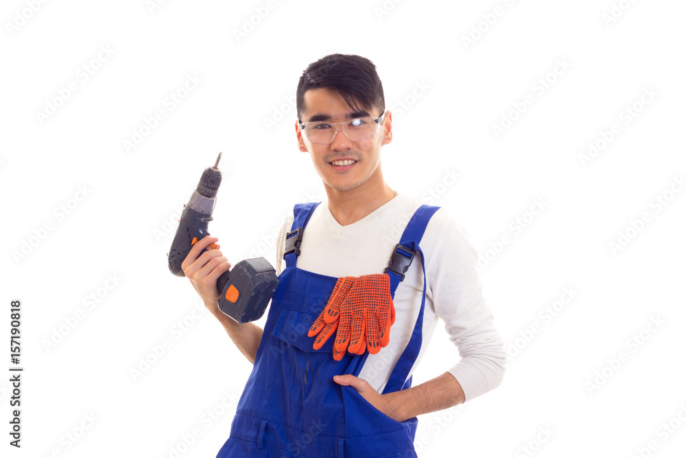 Man in overall with gloves and glasses holding electric screwdriver Man in overall with gloves and glasses holding electric screwdriver