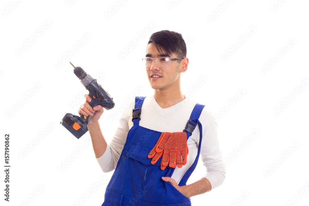 Man in overall with gloves and glasses holding electric screwdriver