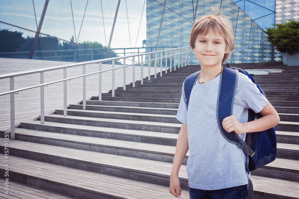 Happy boy with school bag in the city. Education, back to school, travel, leisure concept