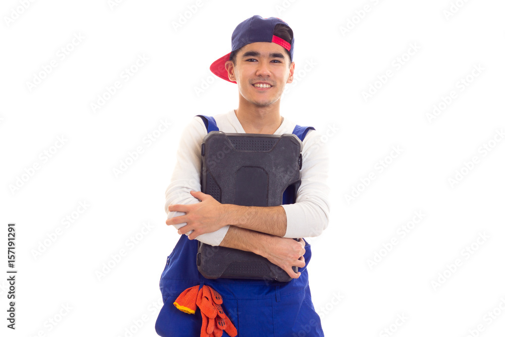 Young man in overall holding toolbox Young man in overall holding toolbox