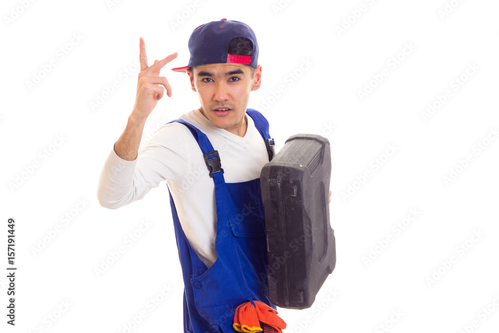 Young man in overall holding toolbox Young man in overall holding toolbox