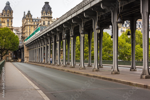 Metal columns and abutments of '' Bir Hakeim '' bridge. People walks and make jogging under the bridge in Paris.The bridge is one of the most famous and historic landmark