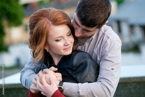 Redhead pretty girl in hugs of handsome brunette man, romantic moment © Kiryl Lis