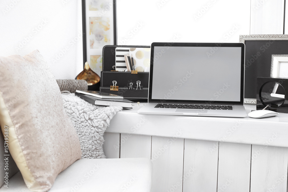 Fototapeta premium Creative workplace with laptop on windowsill in modern room