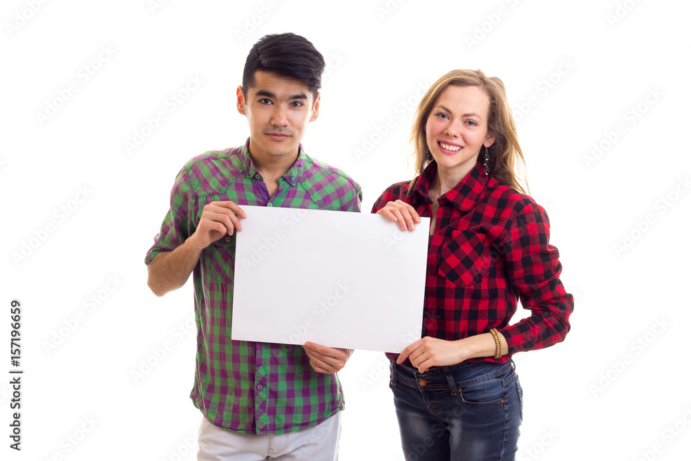 Young couple in plaid shirts holding placard Young couple in plaid shirts holding placard