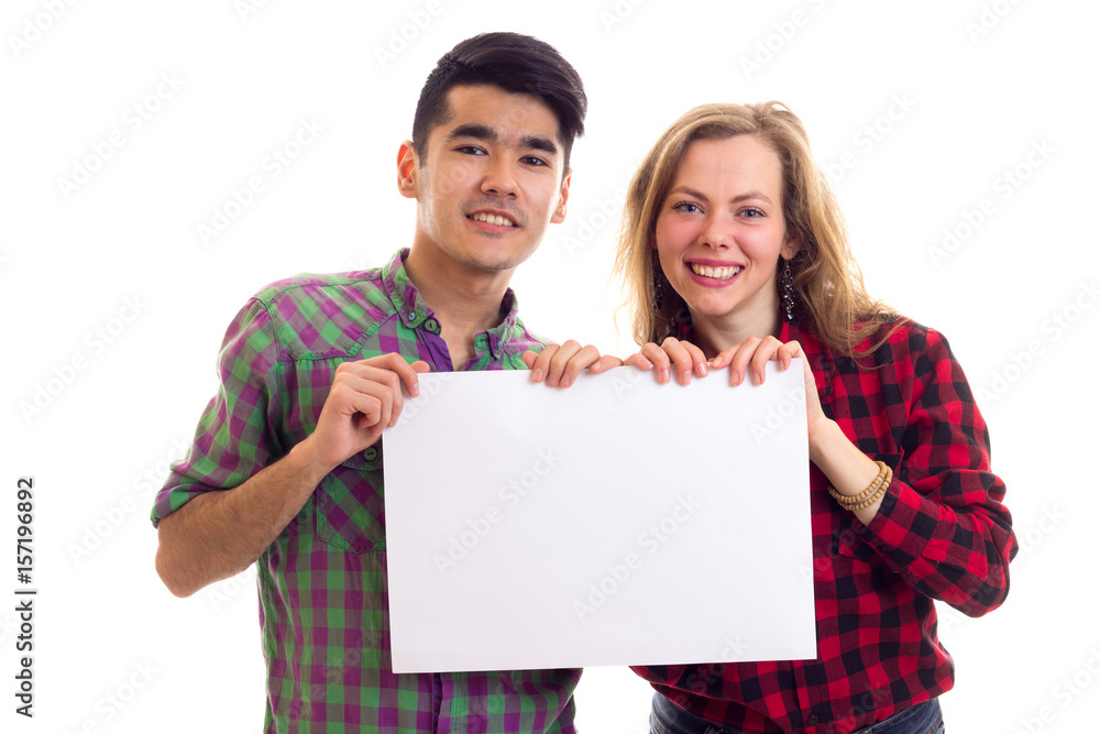 Young couple in plaid shirts holding placard Young couple in plaid shirts holding placard