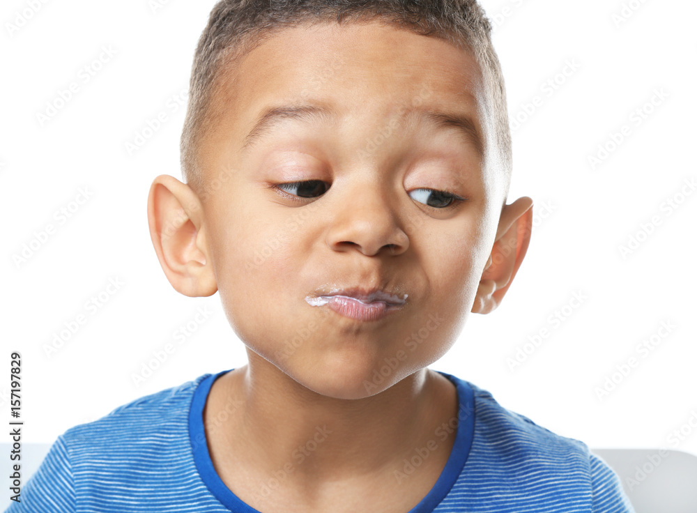 Cute African American boy eating yogurt on white background, closeup Cute African American boy eating yogurt on white background, closeup