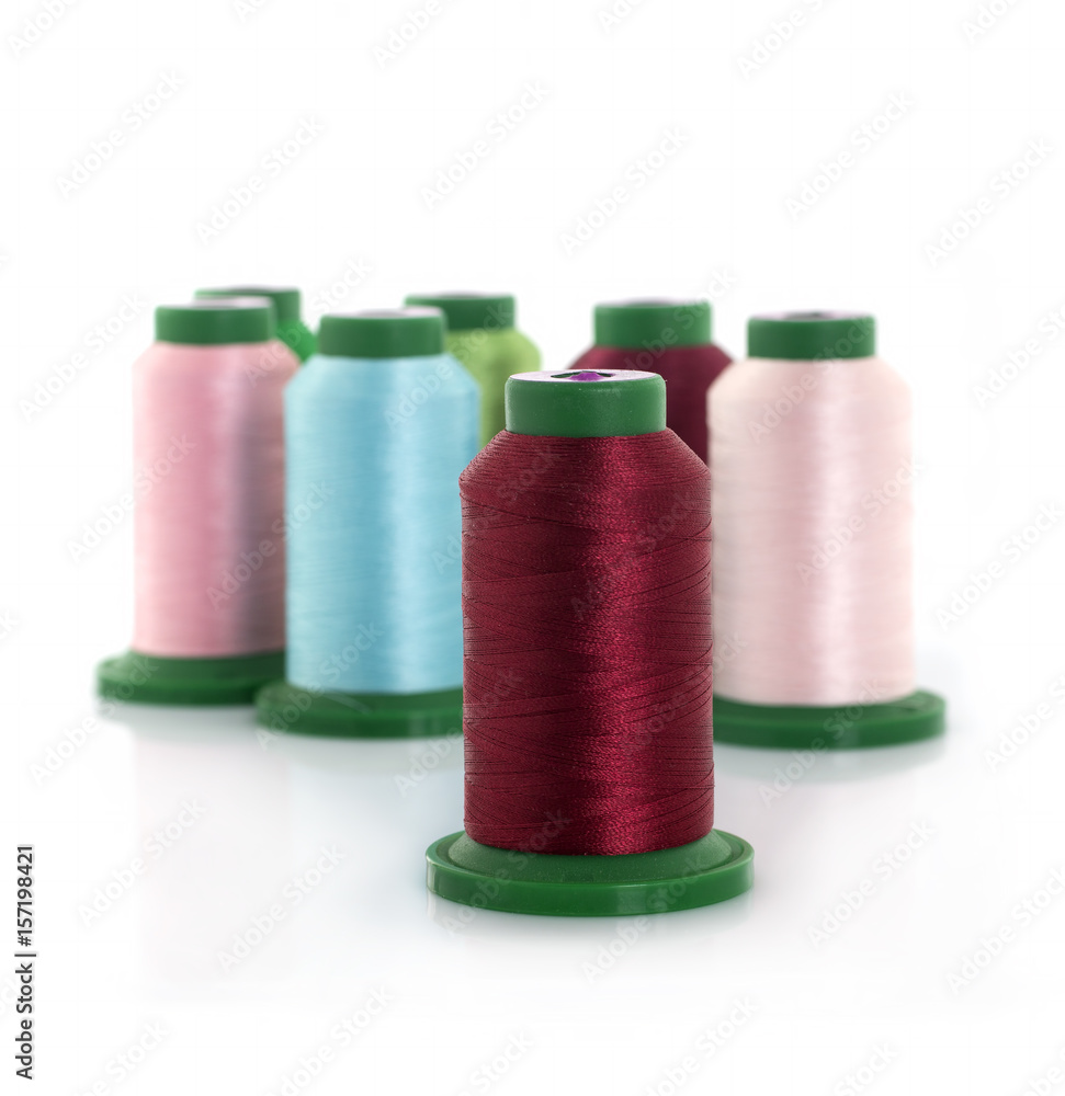 Colored threads on reels on a white background Colored threads on reels on a white background