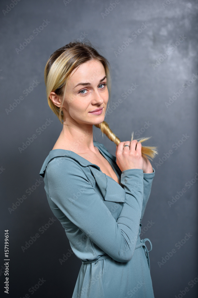 Fototapeta premium The girl keeps his dyed hair in the hands of