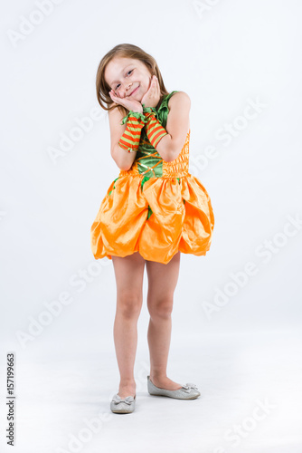 Little girl with pumpink costume smiling photo