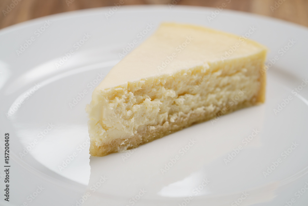 cheesecake on plate on wood table, shallow focus
