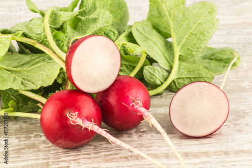 Juicy fresh radish in a cut on a white wooden background close up.