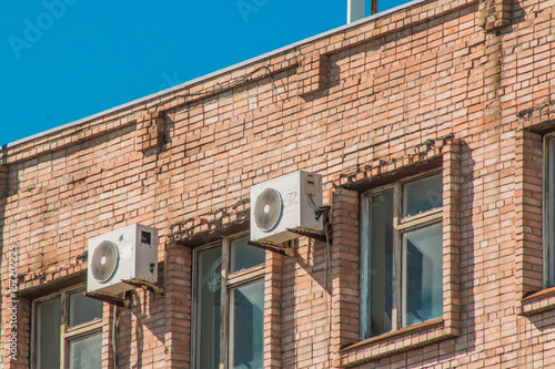 Air conditioners on the wall of an old brick building