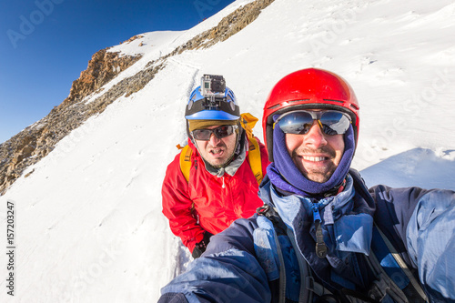 Two climbers mountaineers smiling mountain ridge Huayna Potosi Bolivia.