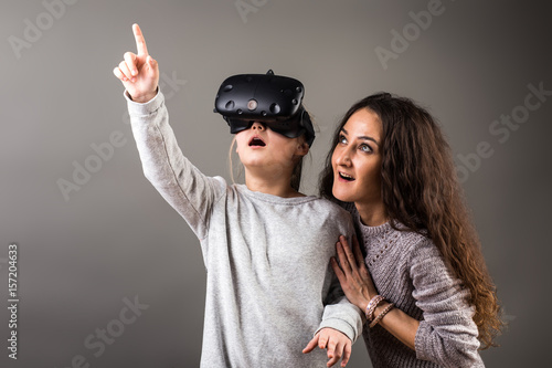 Bild auf Leinwand Happy family! Mother and her child daughter play game in virtual reality glasses