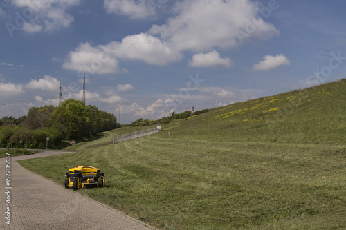 Remotely operated mowing machine mowes grass on a dyke
