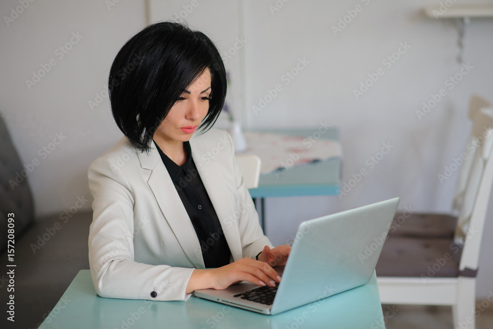business lady dressed in white suit working on a laptop business lady dressed in white suit working on a laptop