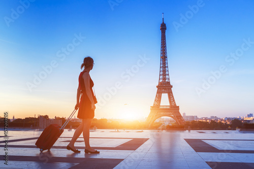 Silhouette of woman tourist with suitcase near Eiffel Tower, Paris © NicoElNino