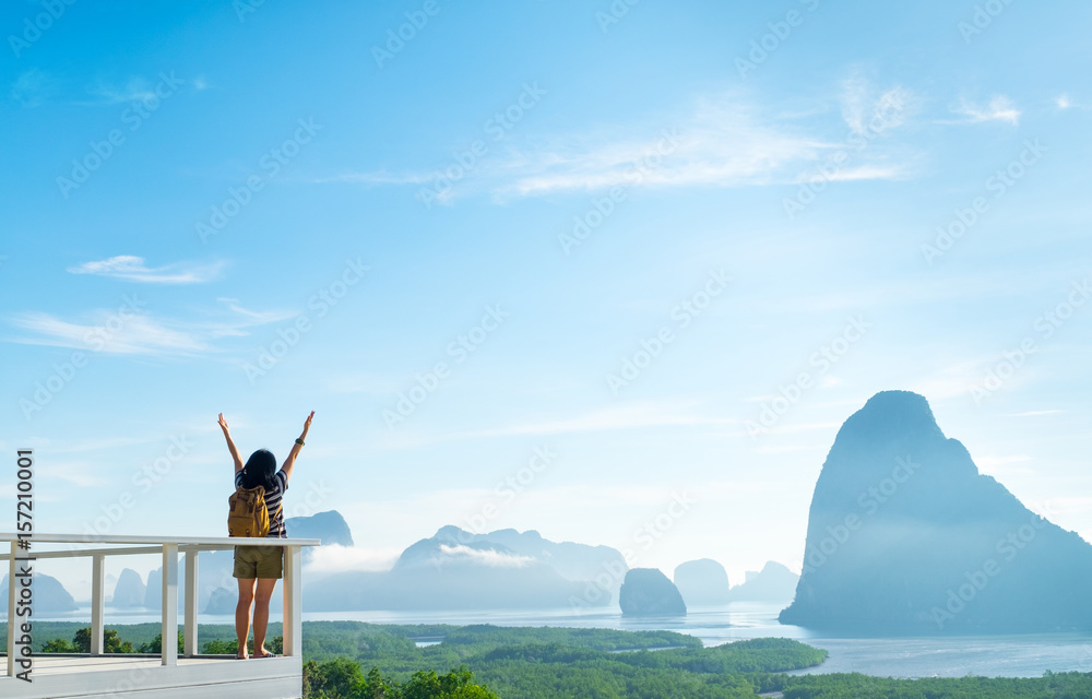 Happy young traveler woman backpacker raised arm up to sky enjoying a beautiful of nature at mountain panorama view point and sea,Freedom wanderlust,Khao Samed Nang Chee Viewpoint,Phang Nga,Thailand. - obrazy, fototapety, plakaty 