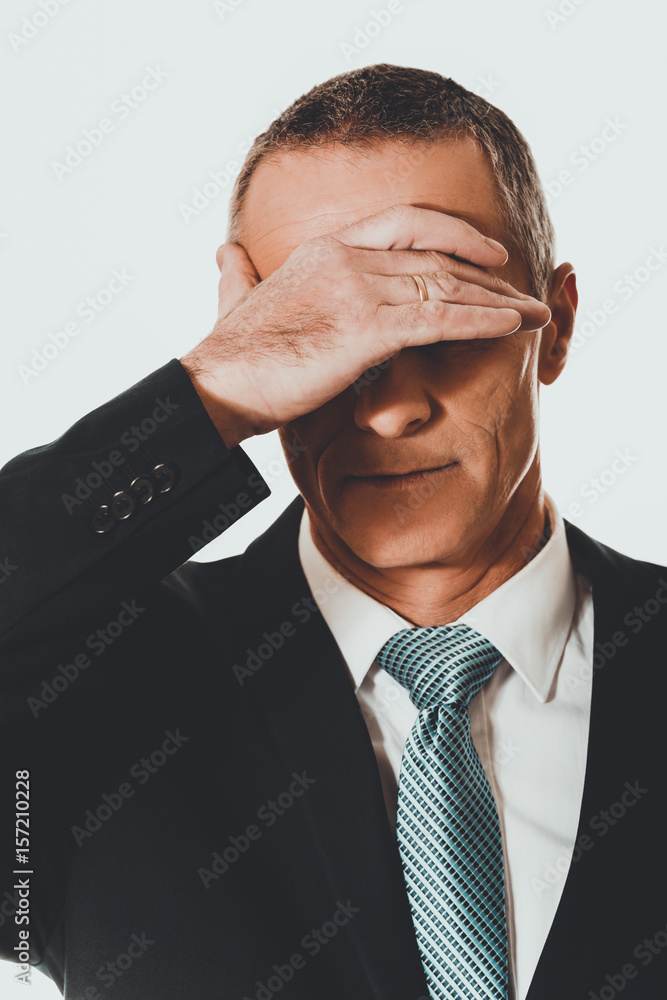 Portrait of stressed businessman covering his face Portrait of stressed businessman covering his face