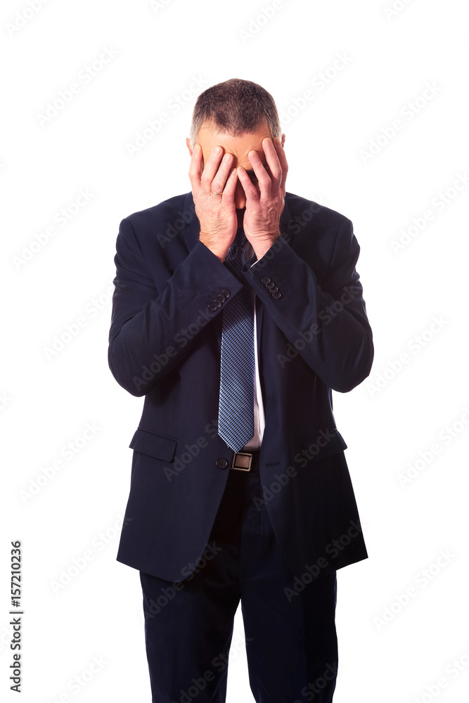 Stressed businessman covering his face with hands Stressed businessman covering his face with hands