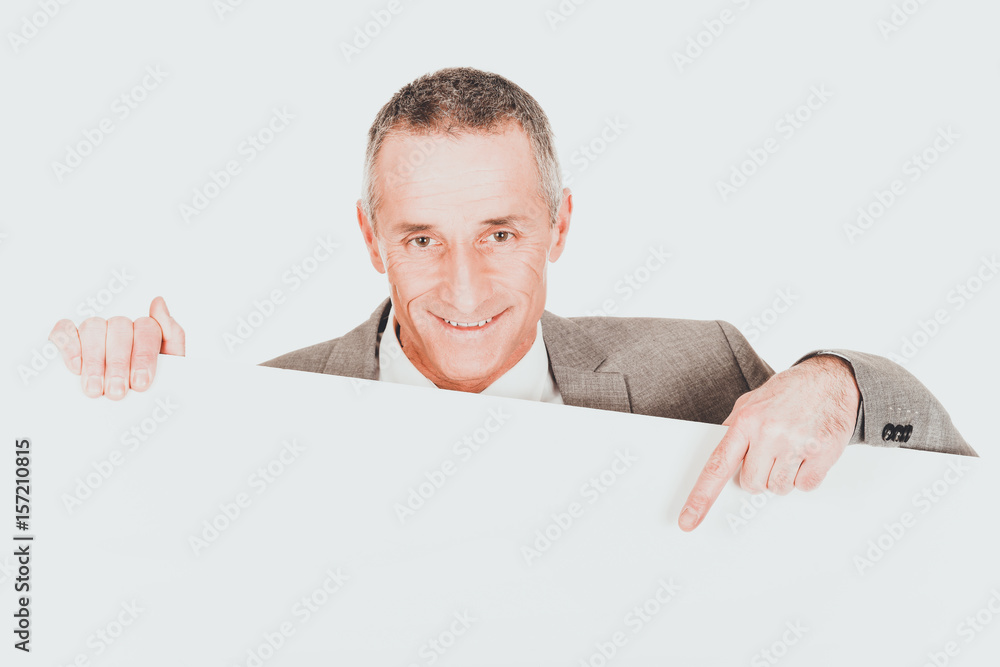 Smiling businessman pointing on empty banner Smiling businessman pointing on empty banner