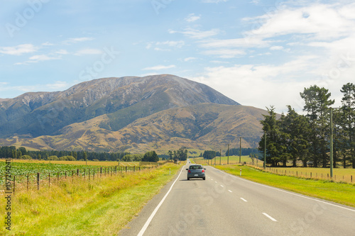 Rural Scene of Asphalt Road with Meadow and Mountain Range, South Island, New Zealand