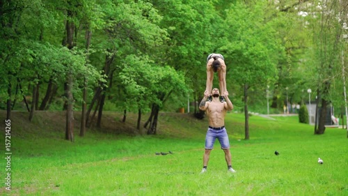 A guy and a girl are doing sports, aerial gymnastics in the park photo