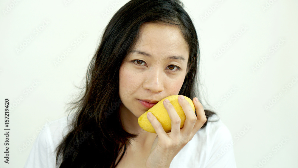 Asian beautiful woman eating posing with mango. Summer delight tropical fruit.
