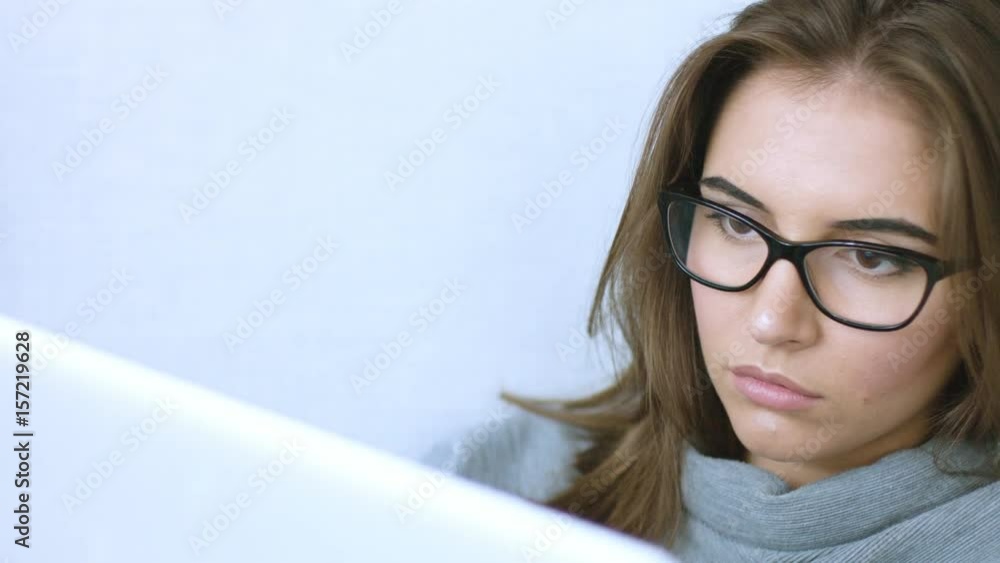 Attractive young woman in glasses using laptop Attractive young woman in glasses using laptop