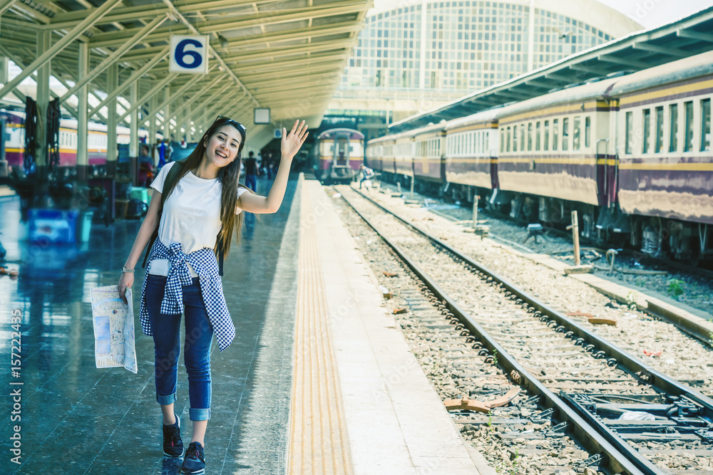 Asia woman Traveller feeling happiness and greeting her friend before go to travel at the train station, Travel and lifestyle concept