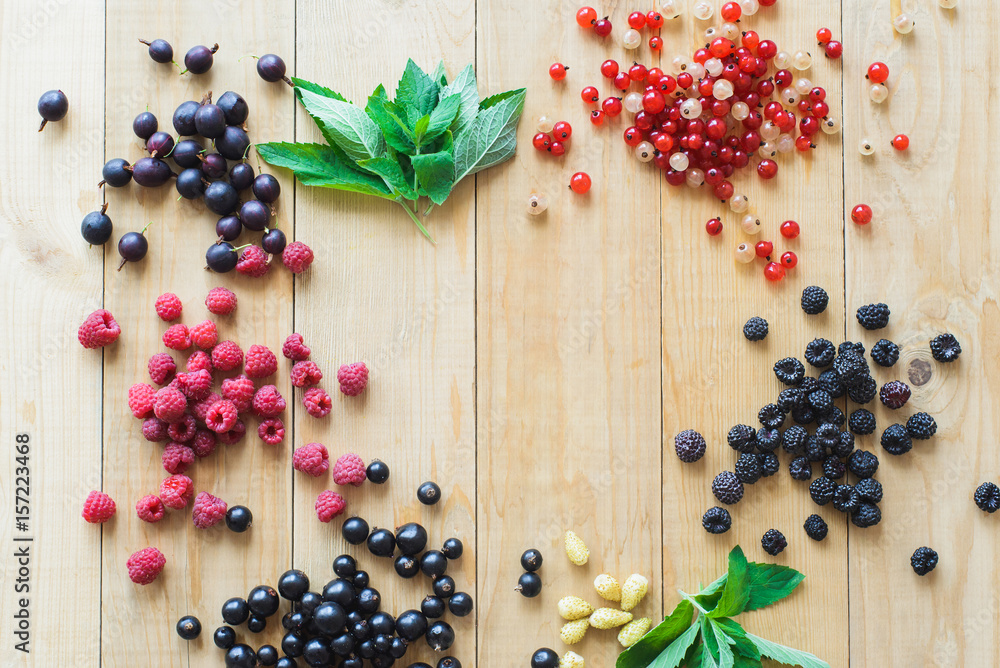 Red, white, black currant, red and black raspberries, white strawberries and mint leaves with glass jar on wooden table as ingredient to healthy cocktail, beverage, yogurt, smoothie Red, white, black currant, red and black raspberries, white strawberries and mint leaves with glass jar on wooden table as ingredient to healthy cocktail, beverage, yogurt, smoothie