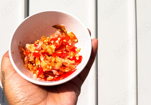 man's hand holding the red Chili crushed and chooped photo