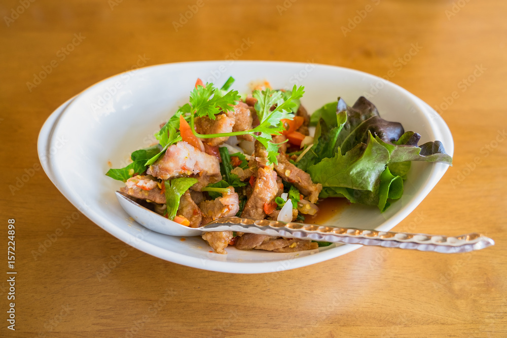 Spicy salad of sliced grilled pork Thai food on wood background Spicy salad of sliced grilled pork Thai food on wood background