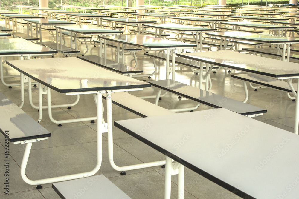 Rows of tables in the cafeteria for students.