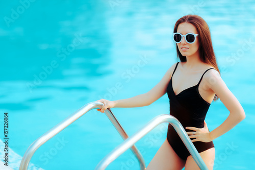 Summer Girl with Fashion Sunglasses and Black Swimsuit by the Pool