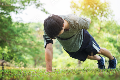 hand push-up. Confident muscled young man wearing sport wear and doing hand push-up while exercising on outdoor park