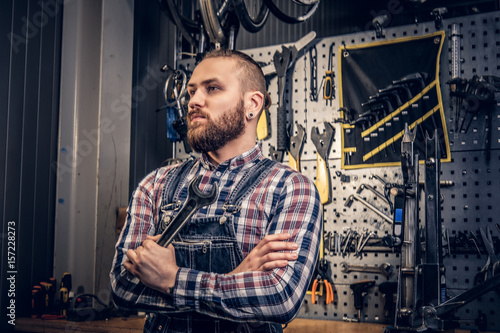 Portrait of bearded bicycle mechanic with crossed arms.