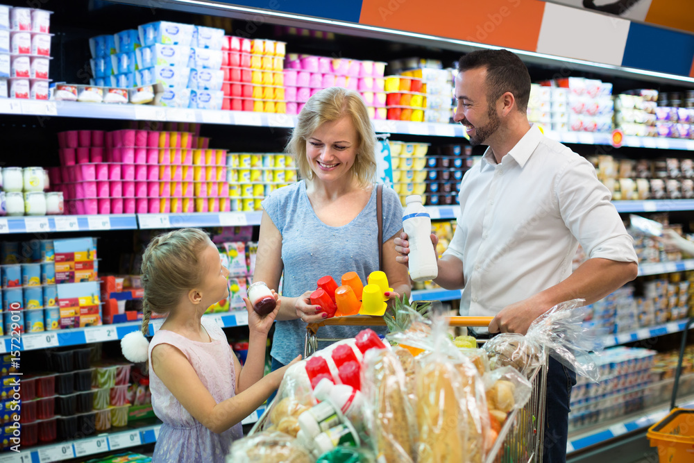 Family picking milk products in food store.