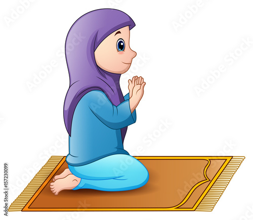 Muslim girl sitting on the prayer rug while praying