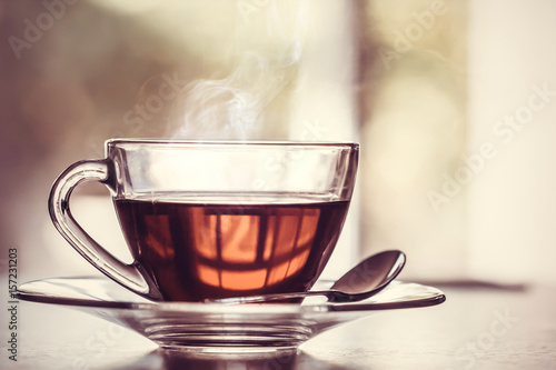 Close up the warm black tea cup on the wooden table in living room , relax with tea time concept