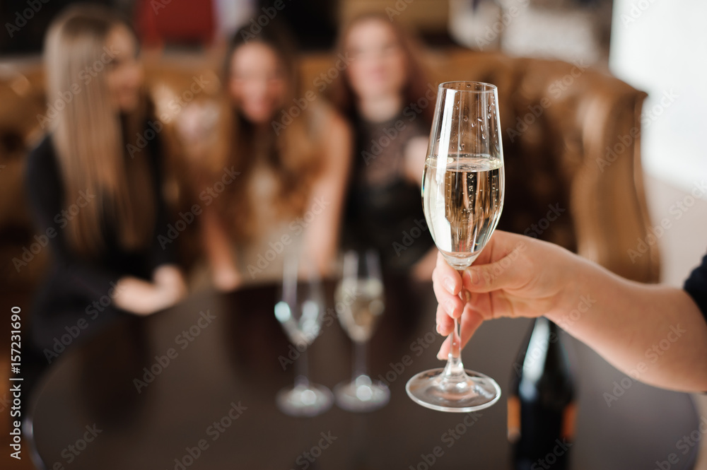 glass of champagne on the background of friends at a party glass of champagne on the background of friends at a party