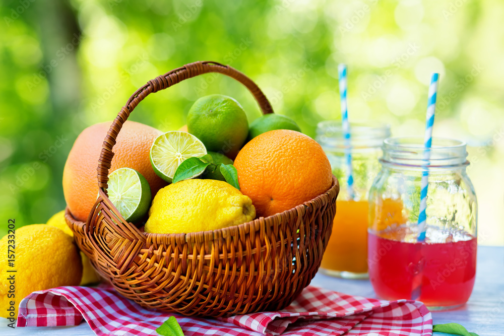 Mix of fresh citrus fruits in basket and juice