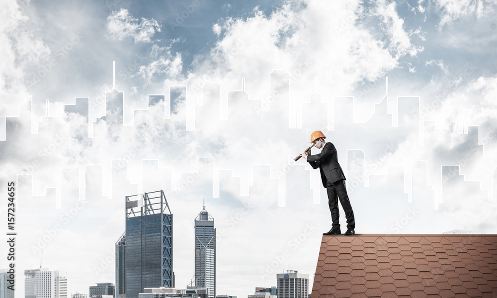 Engineer man standing on roof and looking in spyglass. Mixed med Engineer man standing on roof and looking in spyglass. Mixed med