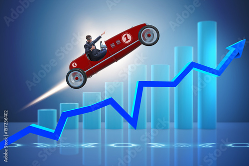 Businessman riding sports car against charts photo