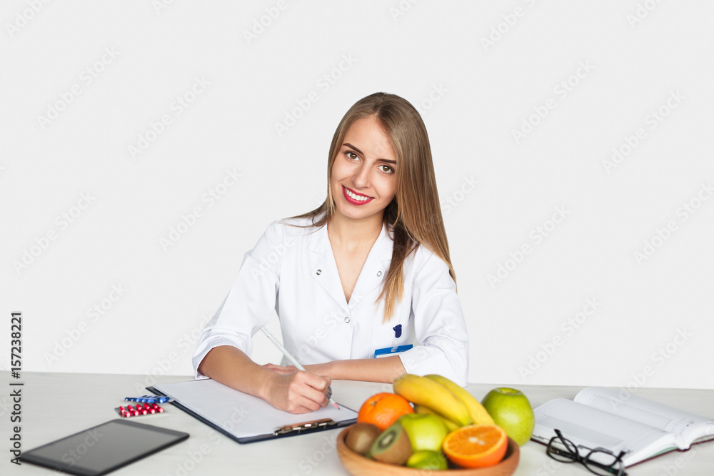 Smiling doctor at table writing Smiling doctor at table writing