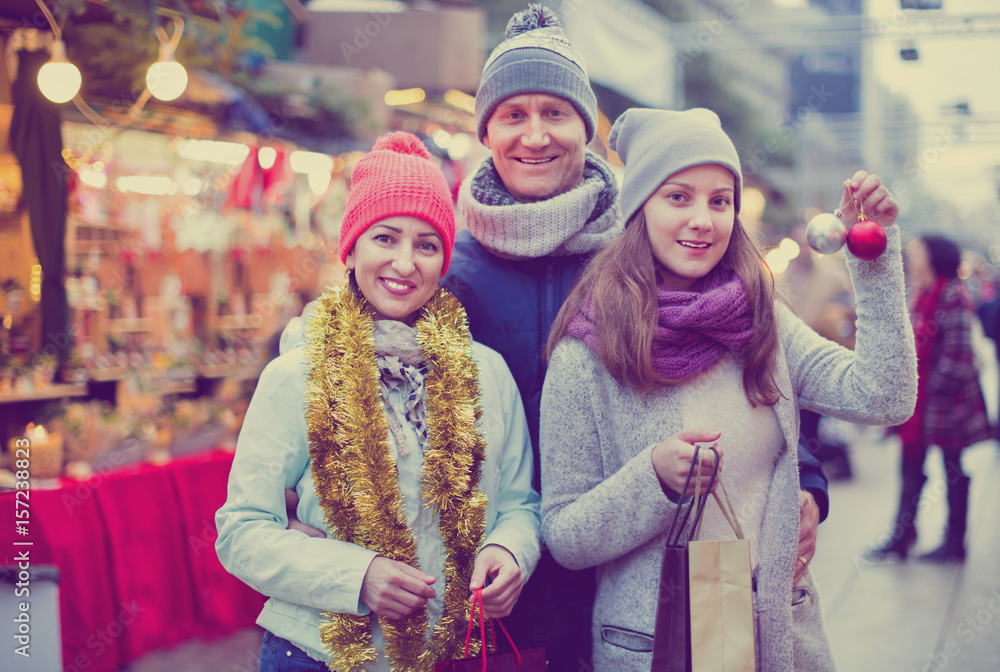 Fototapeta premium Family of three posing at Christmas market