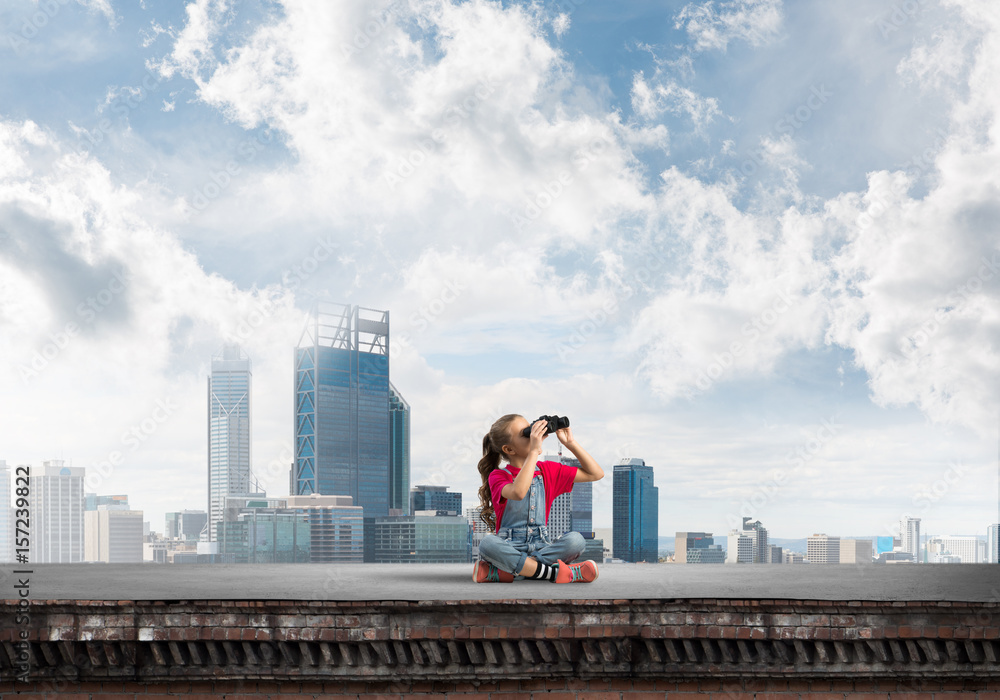 Naklejka premium Concept of careless happy childhood with girl of school age looking in future